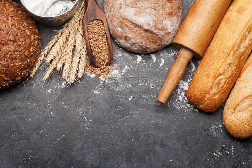 小麦面粉和石头桌上的用具的各种面包图片