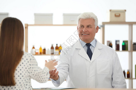 药剂师在药店给顾客送药图片