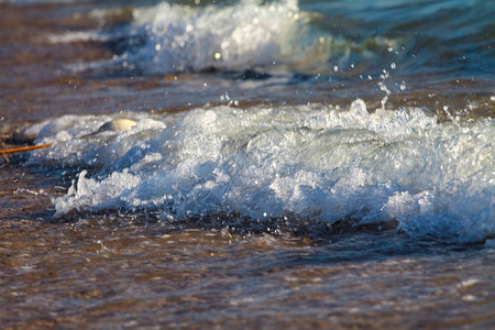 海浪与海边的白色泡沫温暖的大海的夏天海滩海岸由贝壳和沙子组成图片