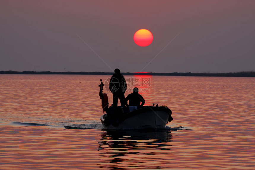 日落时从海中捕鱼归来的渔船图片