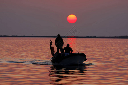 日落时从海中捕鱼归来的渔船图片