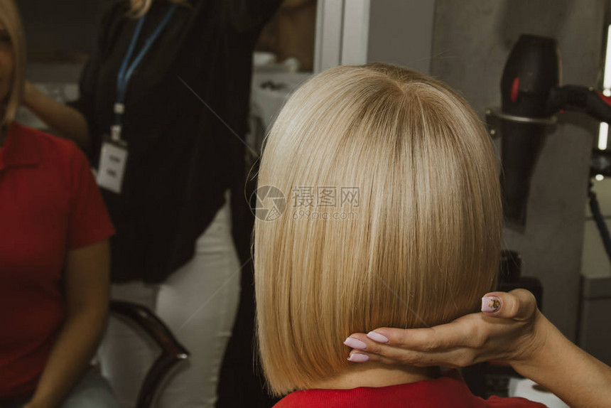 美发师的特写镜头在沙龙剪掉客户的湿白头发理发师剪女人用剪刀头图片