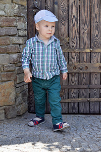 穿着衬衫绿裤子和帽子的小男孩从图片