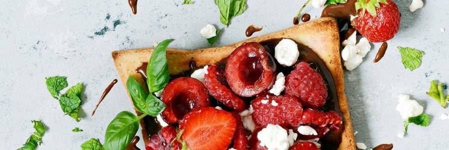 早餐用草莓覆盆子樱桃薄荷和干酪烤面包图片