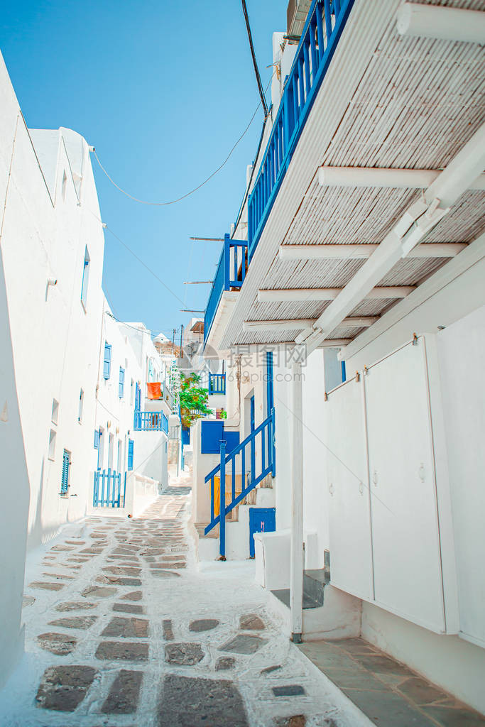 蓝色阳台楼梯和鲜花的狭窄的希腊岛街道图片
