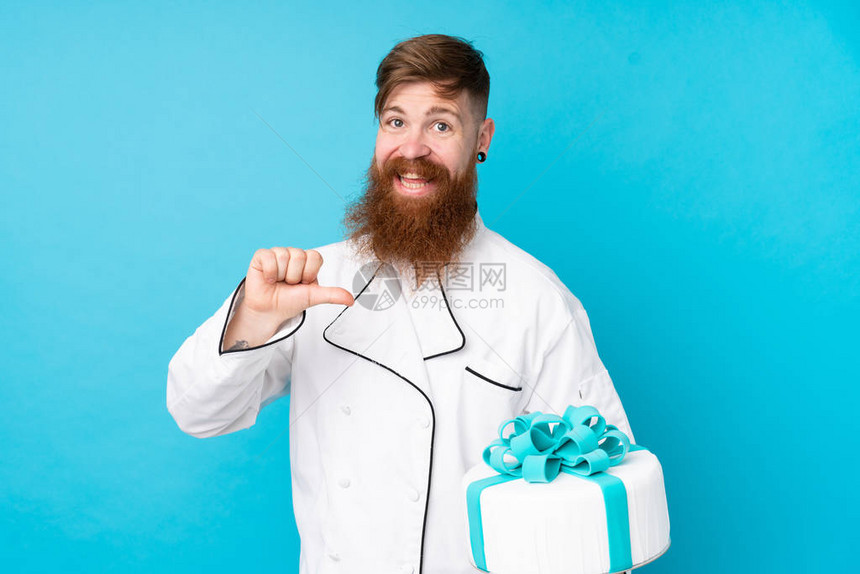 有长胡子的红头发糕饼厨师长胡子拿着一个大蛋糕与孤立的图片