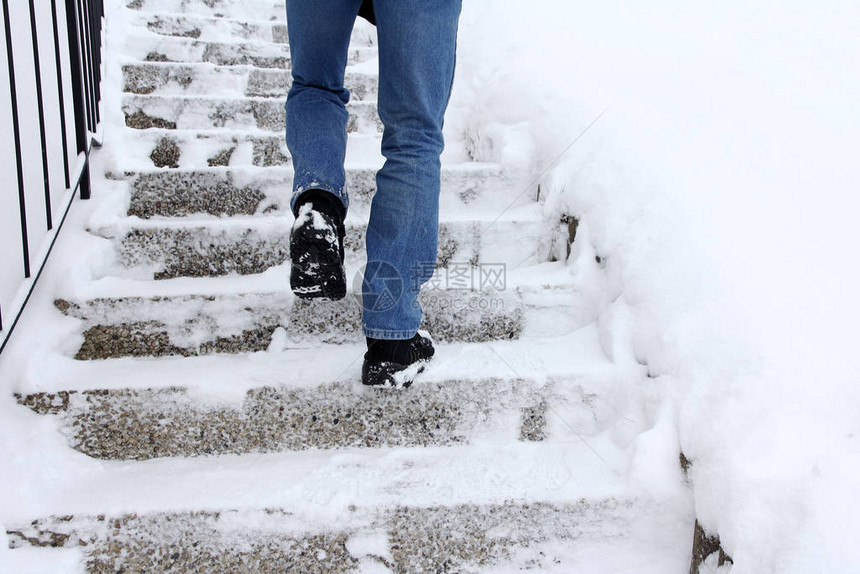 在冬天走上积雪的楼梯很危险一个男人在图片