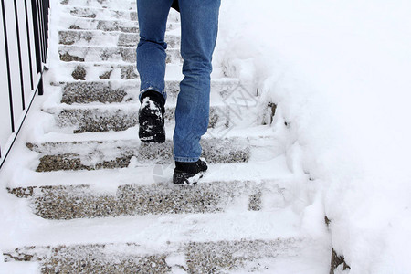 人身损害在冬天走上积雪的楼梯很危险一个男人在背景