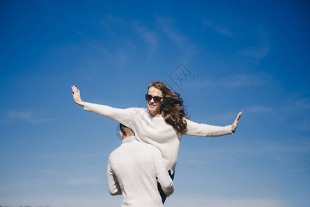 快乐的姑娘和男人跑来去拥抱在空中飞翔旅行爱情故事概念图片