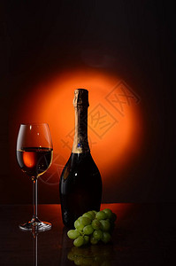 黑色背景的红葡萄酒玻璃和葡萄图片