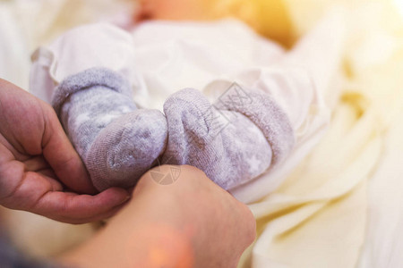 新生婴儿的脚在父母手中爱健康分娩和快乐的年图片