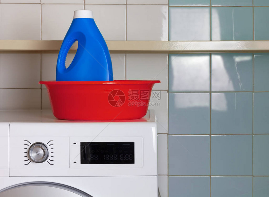 在洗衣房洗衣机顶上一个红洗碗里的蓝色液洗清图片