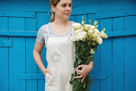 女人花店站在木制复古背景上的白花洋桔梗束洋桔梗洋桔梗创业小企业图片