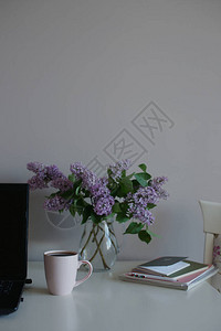 茶杯加玻璃花瓶有紫色立拉克和笔记本电脑图片
