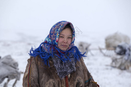 远北苔原驯鹿牧民女帮手身着民族服装图片