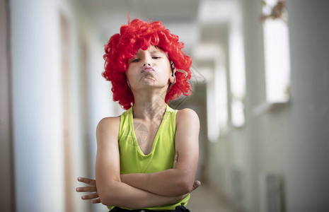 一个戴着明亮假发的小孩戴红色人工毛发的有趣男孩图片