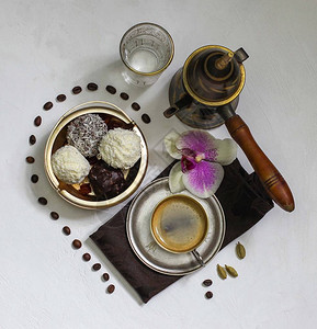 一杯浓缩咖啡糖果碗里的糖果土耳其咖啡壶Orhedea花和浅色背景顶视图上半心形背景图片