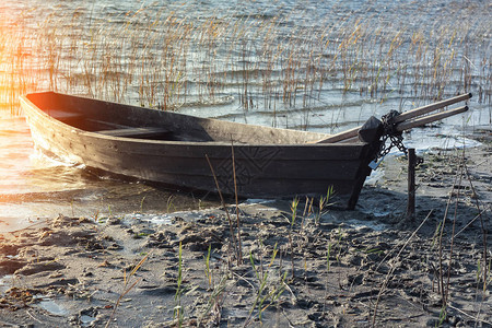 停泊在泥泞的岸湖上的旧木船图片