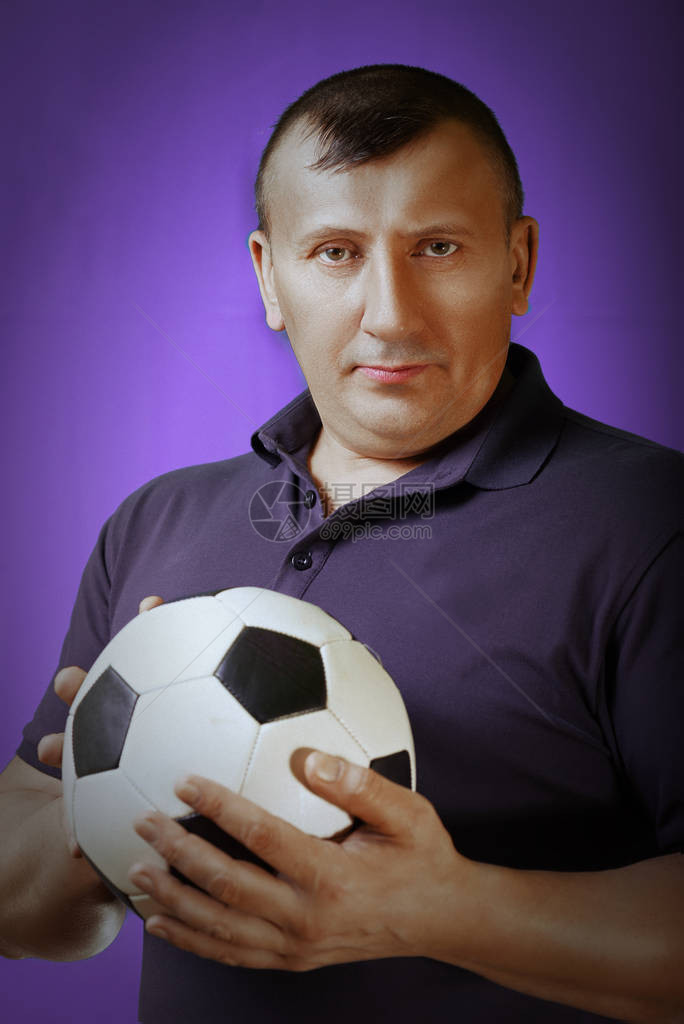 紫色背景上的运动员肖像古铜色皮肤足球运动员展示了进行团队运动的球健图片