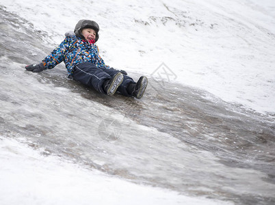 孩子在冰雪滑坡上骑车冬图片