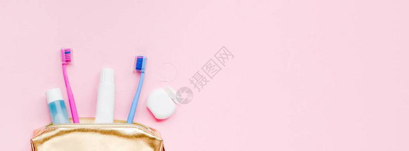 金色旅行化妆品钱包套件中的牙齿卫生和口腔牙科护理产品柔和的粉红色背景图片