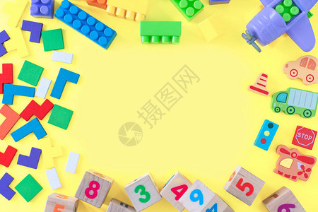 黄色背景的彩色婴儿玩具从开发五颜六色的块汽车和飞机的框架顶视图平躺图片