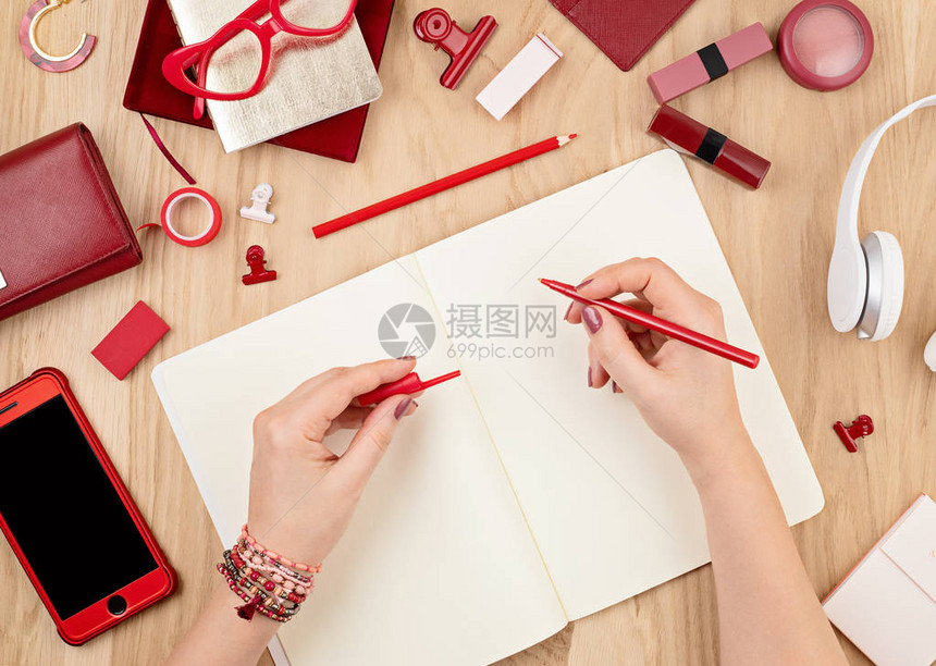 模拟女人手写在空笔记本和红色办公室文具上图片