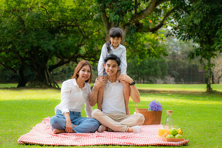 亚洲青少年家庭在公园里度过愉快的假期野餐时刻图片