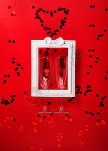 情人节快乐概念公寓在白色浪漫相框中摆放着香槟长笛和红心纸屑图片