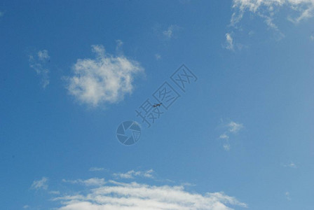 美丽的晴朗蓝天有棉花云还有一小架飞图片