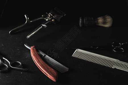黑色背景上的老式理发店设备专业美发工具剪刀手动理发器剃须刀剃须刷梳图片