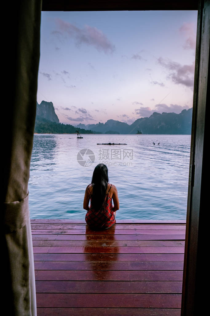 在泰国高索湖漂浮的平房前看日出的女人图片