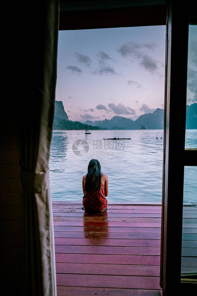 在泰国高索湖漂浮的平房前看日出的女人图片