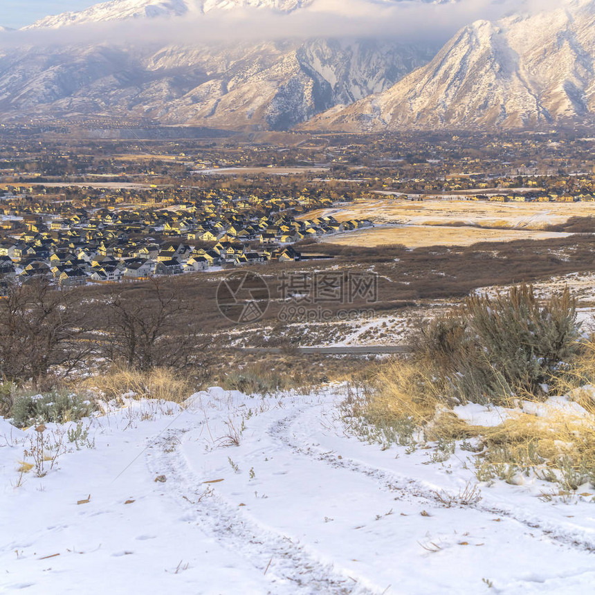 照片方形框架积雪覆盖的蒂帕诺戈斯山耸立在山谷中的邻里房屋之上前景中可以看到丘陵图片