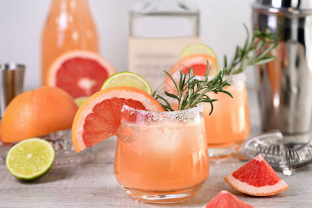 鸡尾酒新鲜酸橙和迷迭香与新鲜葡萄柚汁和龙舌兰酒相结合节日饮品是早午餐聚会和假背景图片