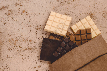 木制背景的黑牛奶和白巧克力条顶视图图片