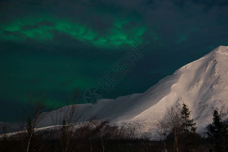 白雪皑的夜山云背后的北极光图片