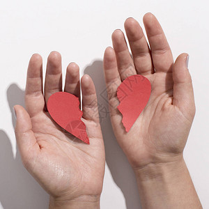 女人手上有两半红纸心脏的红纸心图片