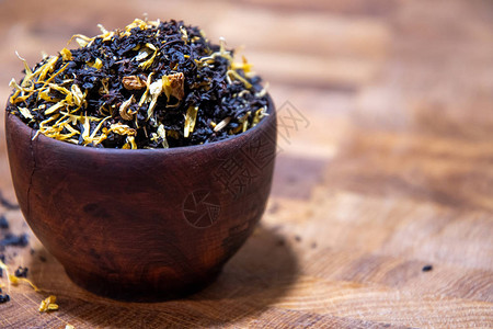 茶和添加剂放在木碗里的茶一个金属茶壶图片