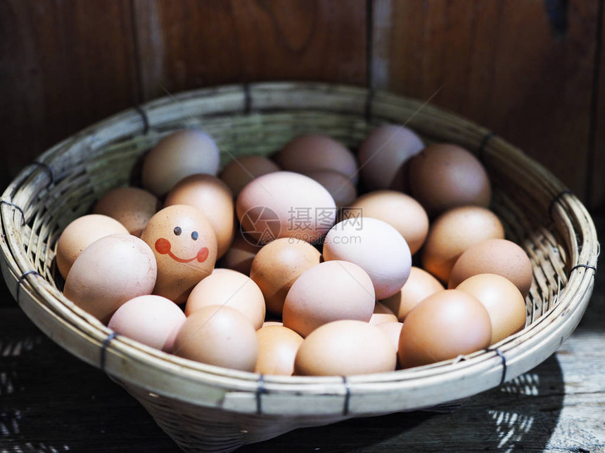 鸡蛋在竹篮上面带笑容的画在木桌上做为复活图片