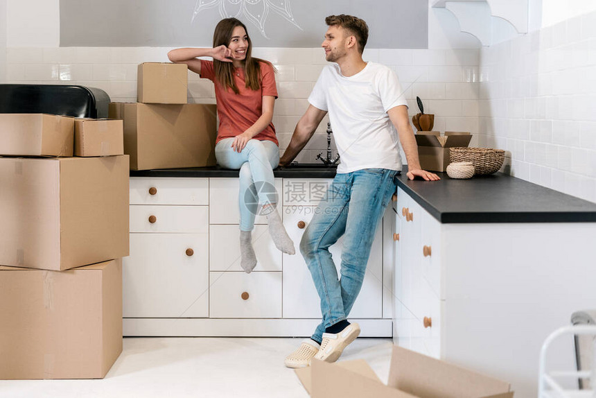快乐的年轻夫妇带着纸箱搬进新房子图片