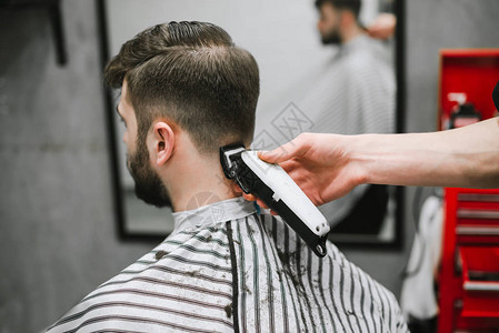 专业的男理发师在理发店给留胡子的人做发型图片