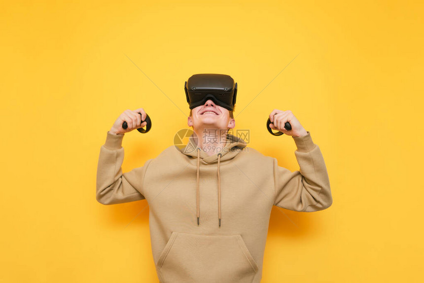 VR眼镜中的快乐的年轻玩家画像和手握控制器的人在胜利中欢欣鼓舞图片