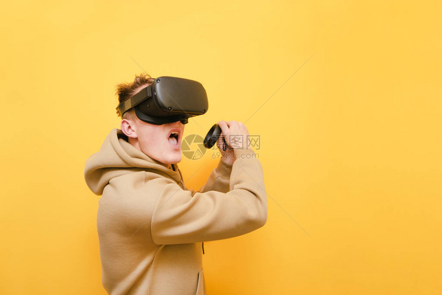 头戴增强现实头盔的情感游戏玩家在控制器上富有表现力地玩图片