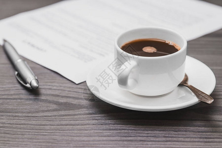 合同签订概念特写杯咖啡银笔和空纸页图片