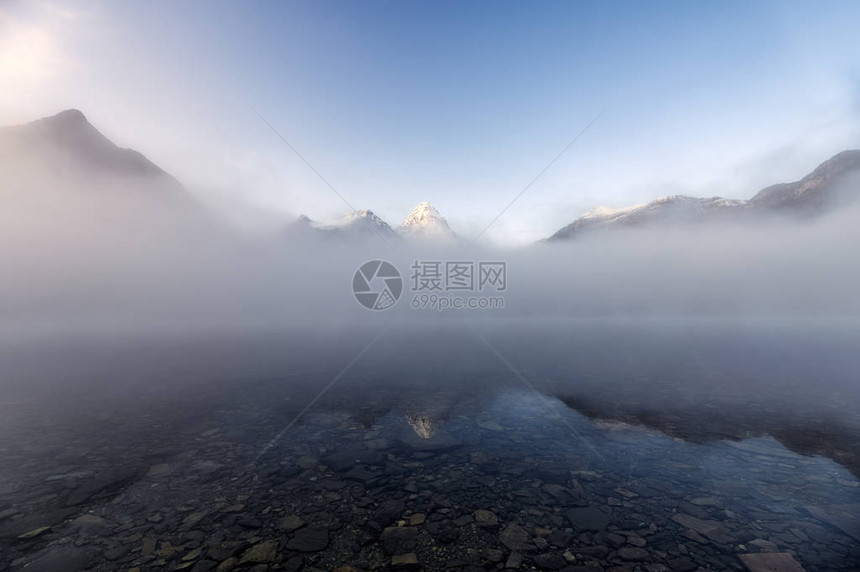 在加拿大不列颠哥伦比亚省公园的Magog湖上进行蓝雾反射的Assini图片