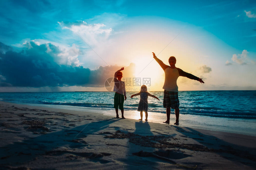 父亲带着儿子和女儿的剪影在日落图片