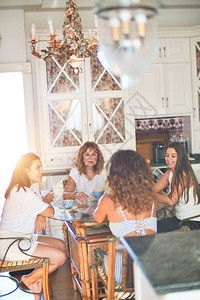 坐在厨房的美丽女群体喝着咖啡图片