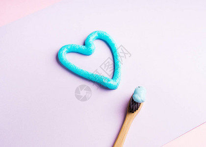 笔牙刷和蓝牙膏心脏在粉色面粉背景上贴画图片