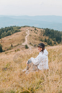 妇女坐在地上看着山峰徒步概图片